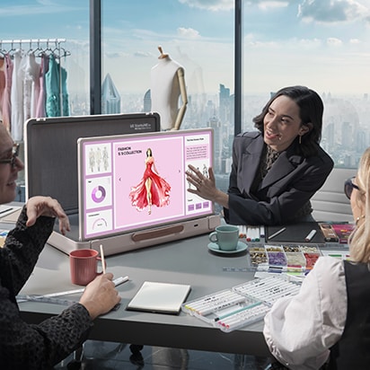 StanbyME Go được đặt trong phòng họp ở văn phòng. Màn hình hiển thị phần thuyết trình về thời trang. Một người phụ nữ chạm vào màn hình.