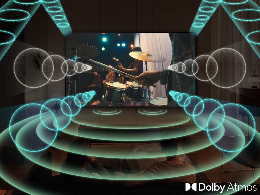 TV Samsung phát cảnh một ban nhạc biểu diễn với trọng tâm là tay trống. TV phát ra các vòng âm thanh ở nhiều kích cỡ khác nhau, phát ra các xung mạnh mẽ và truyền theo mọi hướng để lấp đầy không gian, cho biết bạn đang sử dụng tính năng Dolby Atmos.